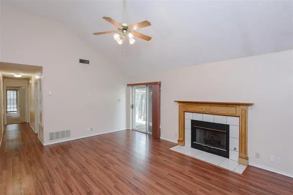 an empty room with wooden floor a fireplace