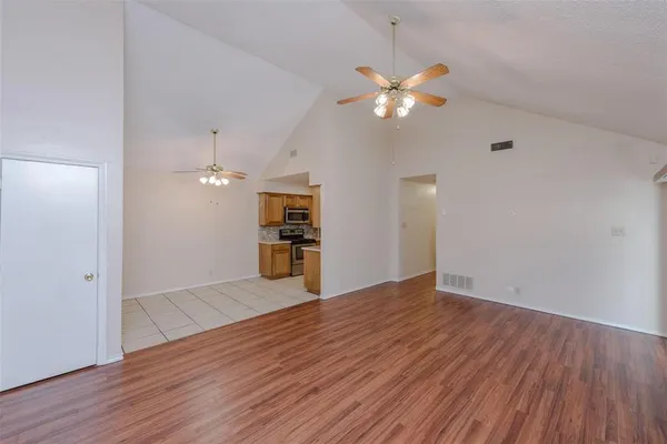 a view of empty room with wooden floor