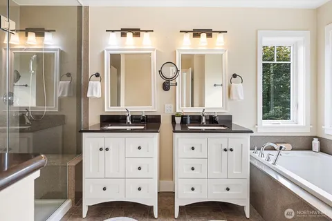 a spacious bathroom with a granite countertop sink mirror and bathtub
