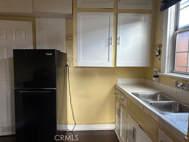 a kitchen with a refrigerator a sink and cabinets