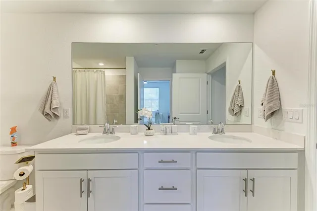 a spacious bathroom with a double vanity sink mirror and