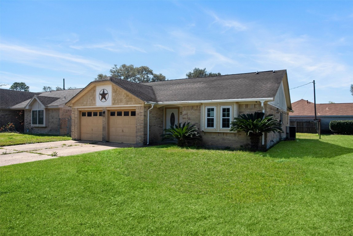 504 Raymond Street La Marque, TX 77568 - Photo 2 of 22 a front view of a house with a yard and garage