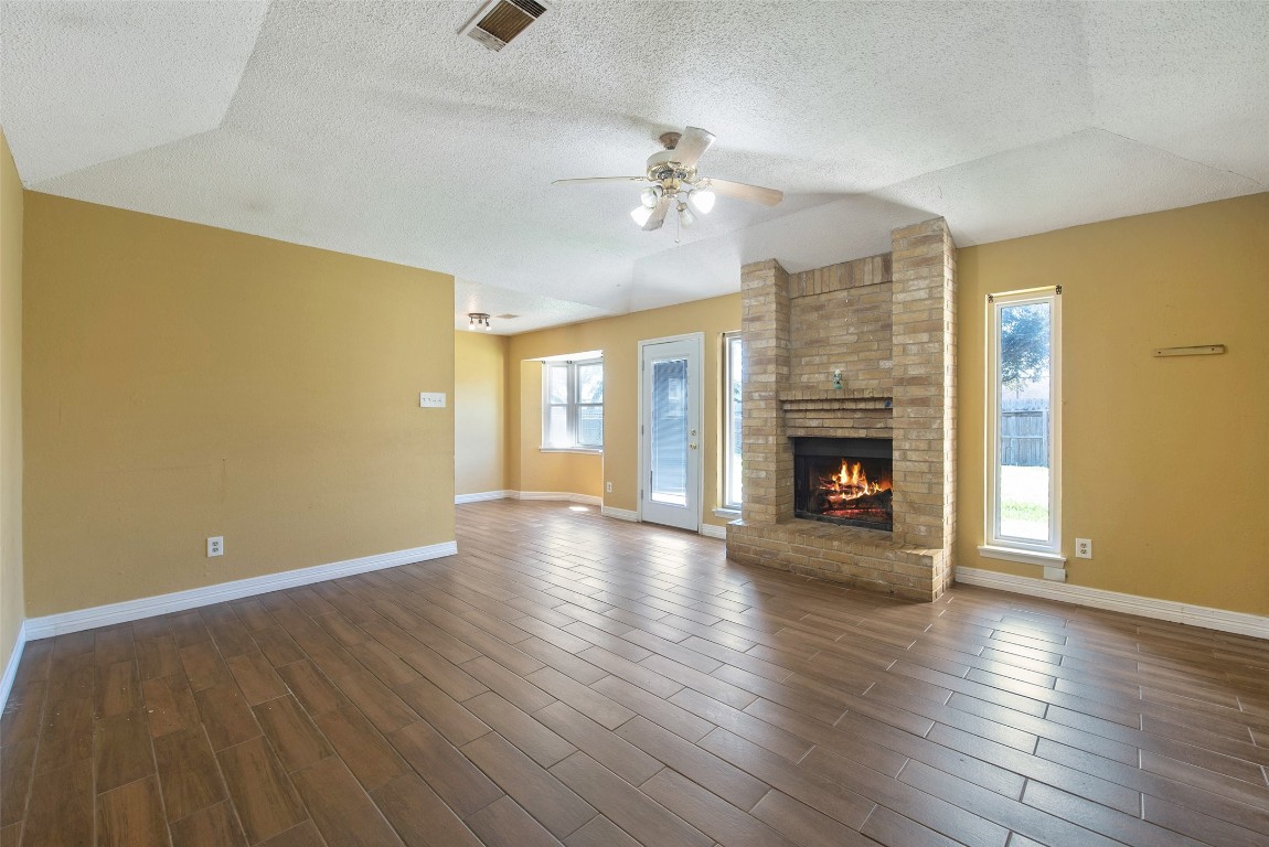 504 Raymond Street La Marque, TX 77568 - Photo 7 of 22 an empty room with wooden floor fireplace and window