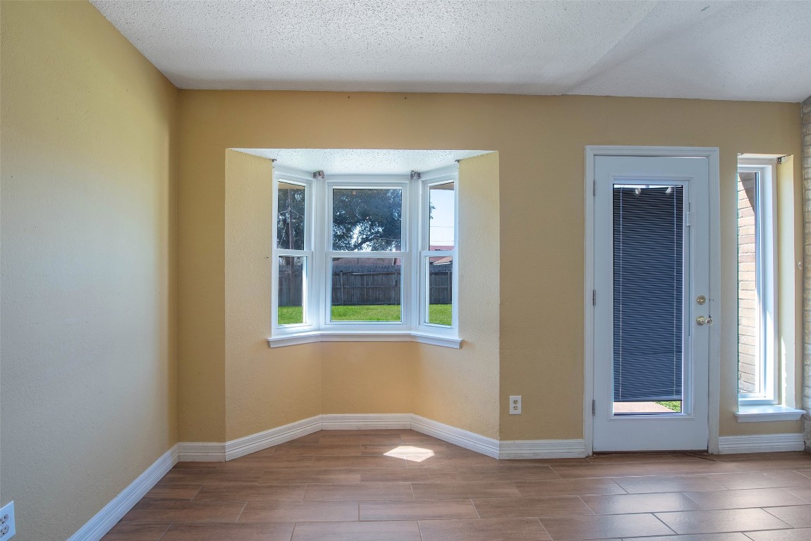 504 Raymond Street La Marque, TX 77568 - Photo 10 of 22 a view of an empty room with wooden floor and a window