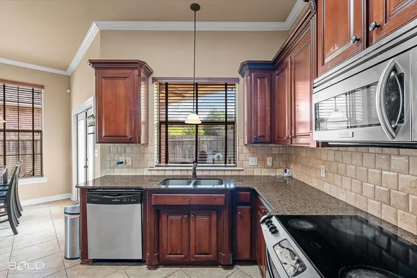 a kitchen with stainless steel appliances granite countertop a sink stove and cabinets