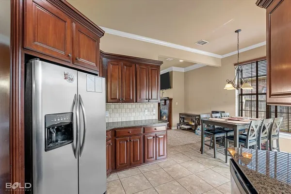 a kitchen with stainless steel appliances granite countertop a refrigerator and a stove top oven