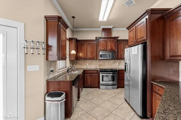 a kitchen with stainless steel appliances granite countertop a refrigerator and a stove