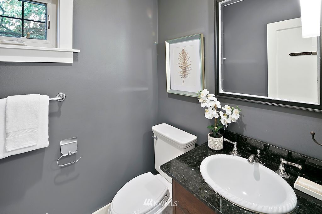 2801 28th Avenue West Seattle, WA 98199 - Photo 19 of 39 a bathroom with a toilet a sink and mirror