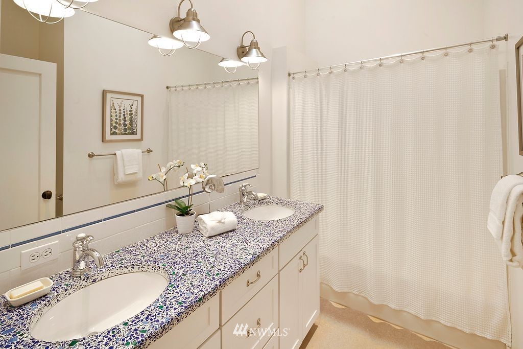 2801 28th Avenue West Seattle, WA 98199 - Photo 26 of 39 a bathroom with a granite countertop sink and a mirror