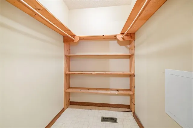 a view of walk in closet with empty racks