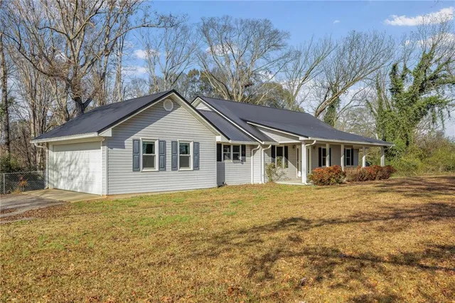 a front view of house with yard and trees in the background