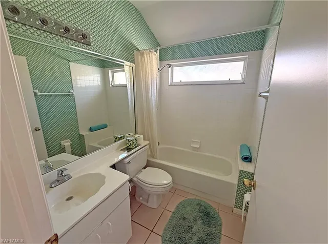 a view of a hallway to a livingroom with wooden floor and furniture