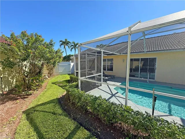 a view of a garden with a chair and potted plants