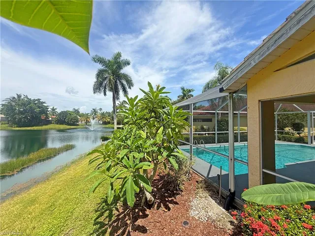 a front view of a house with a yard and potted plants