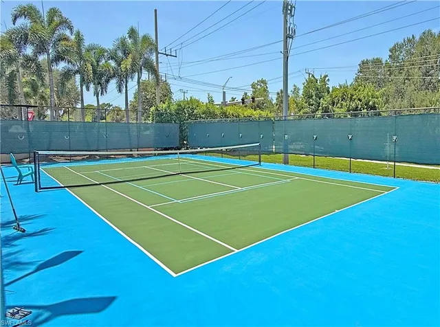 a view of a swimming pool with a bench and trees in the background