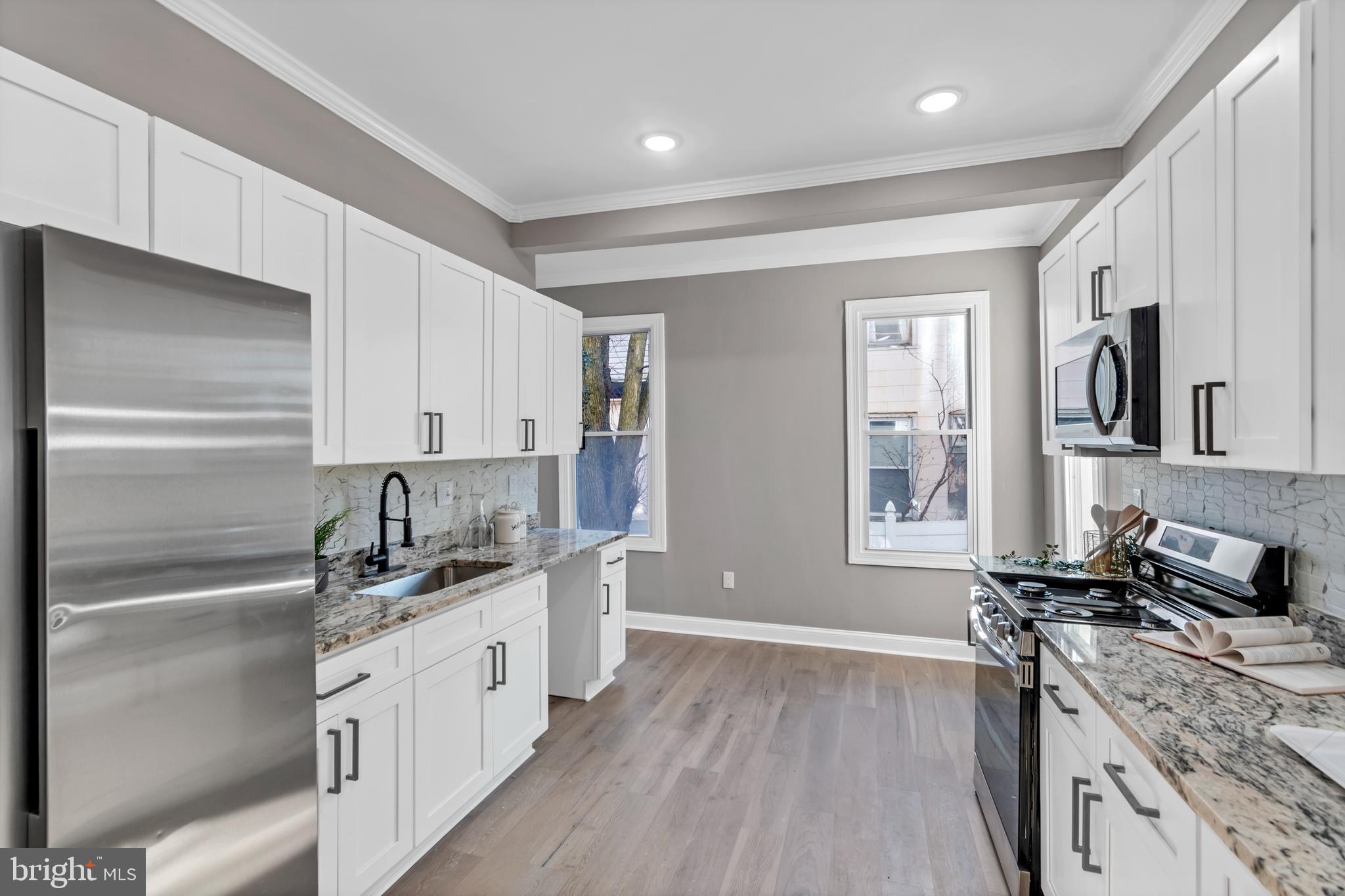 12 South Augusta Avenue Baltimore, MD 21229 - Photo 27 of 38 a kitchen with granite countertop a sink stainless steel appliances and cabinets