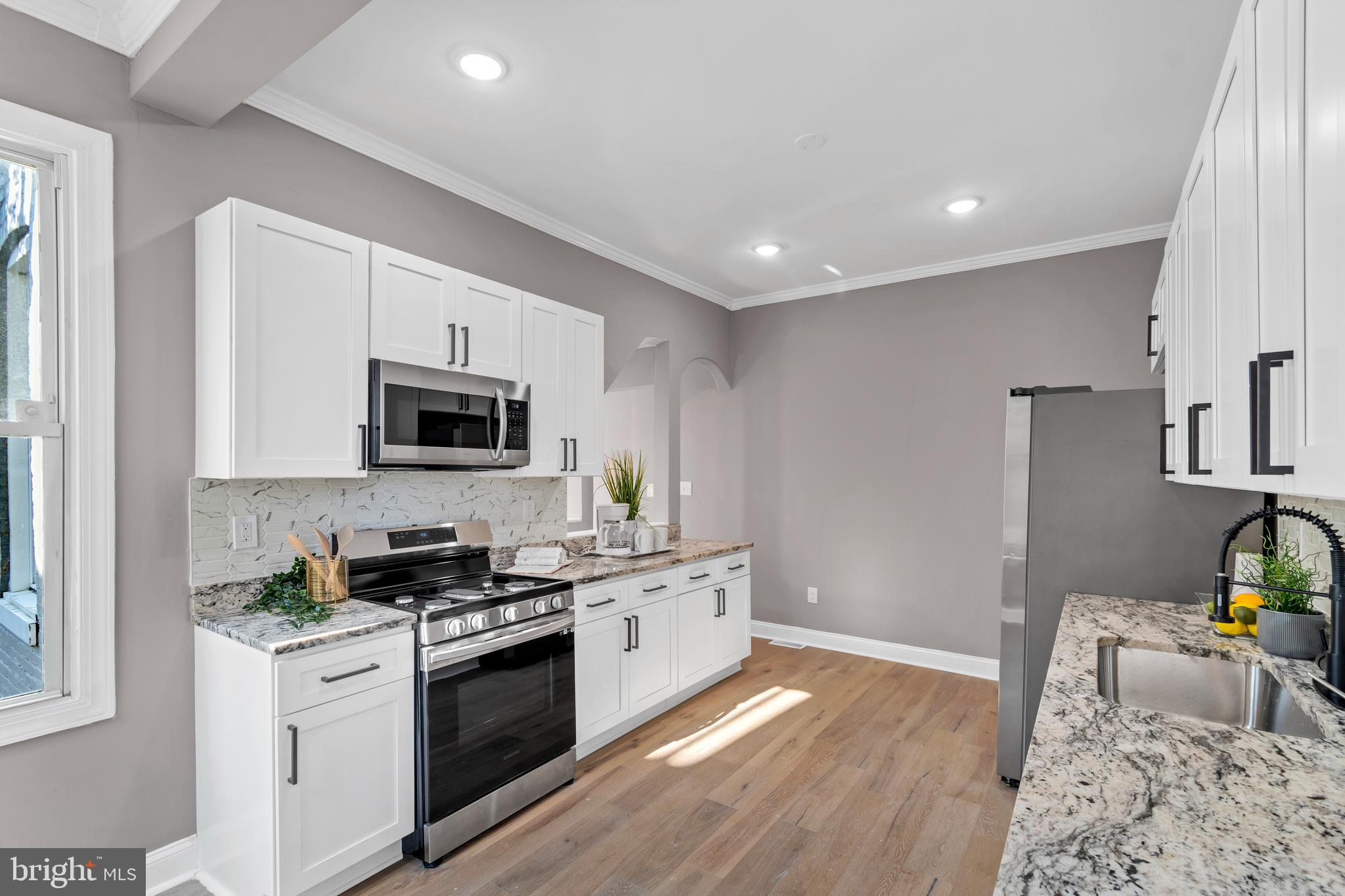 12 South Augusta Avenue Baltimore, MD 21229 - Photo 4 of 38 a kitchen with stainless steel appliances granite countertop a stove a sink and a refrigerator