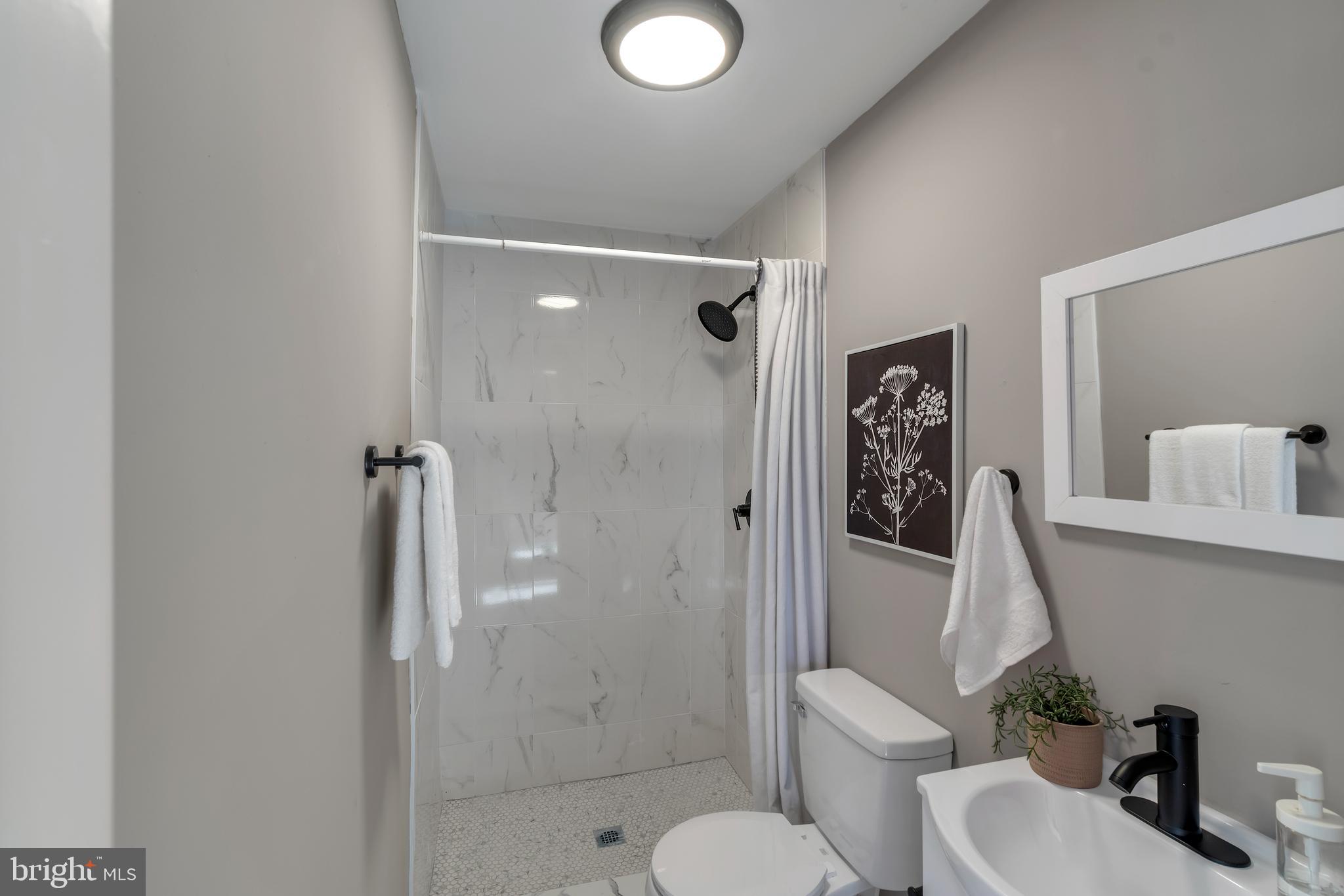 12 South Augusta Avenue Baltimore, MD 21229 - Photo 10 of 38 a bathroom with a shower a toilet and sink