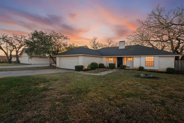 a view of a yard in front of a house with large trees
