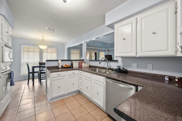 a kitchen with white cabinets appliances and a center island