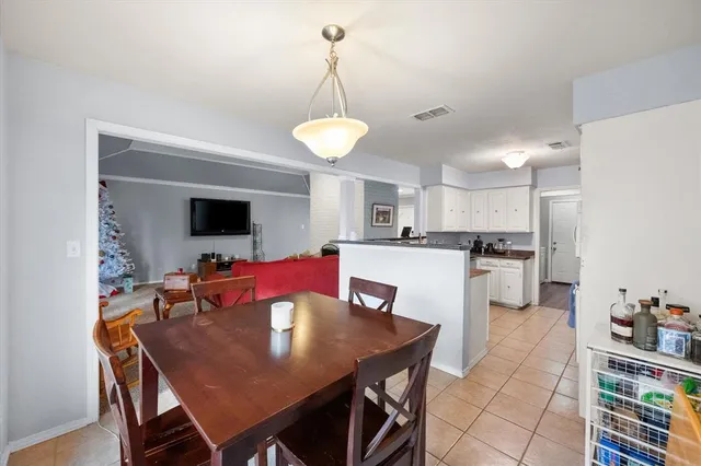 a view of a dining room and livingroom with furniture wooden floor a rug a chandelier