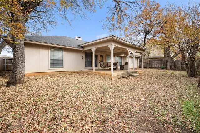 a front view of a house with a yard covered with snow and trees