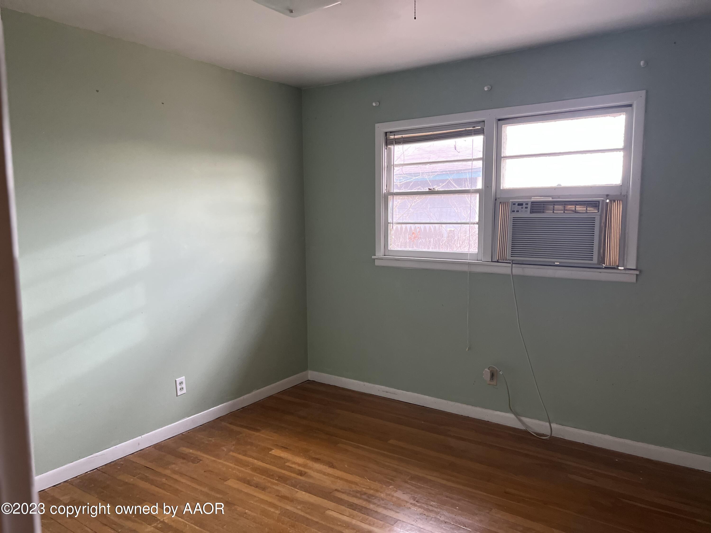 4713 South Rusk Street Amarillo, TX 79110 - Photo 5 of 9 an empty room with wooden floor and windows