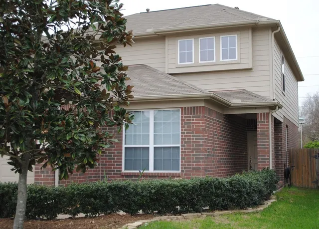 a view of a house with a yard and potted plants