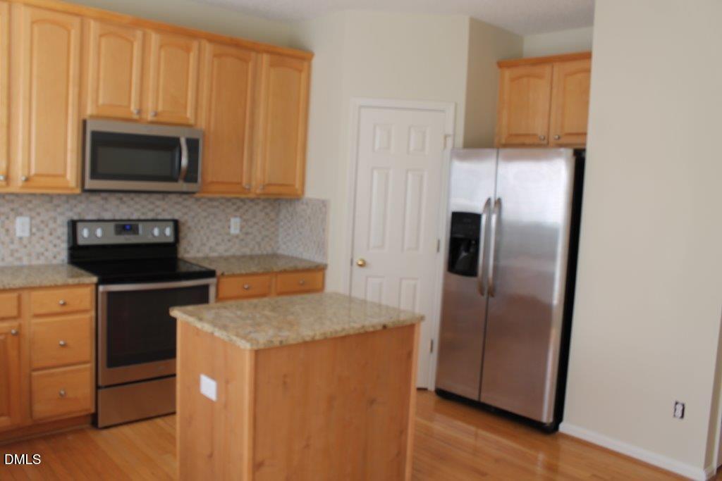 4717 Delta Lake Drive Raleigh, NC 27612 - Photo 6 of 20 a kitchen with stainless steel appliances granite countertop a refrigerator a stove a sink and a microwave