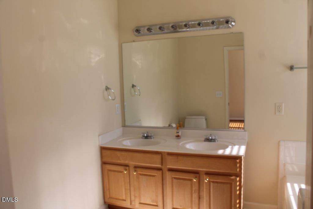 4717 Delta Lake Drive Raleigh, NC 27612 - Photo 9 of 20 a bathroom with a sink and a mirror