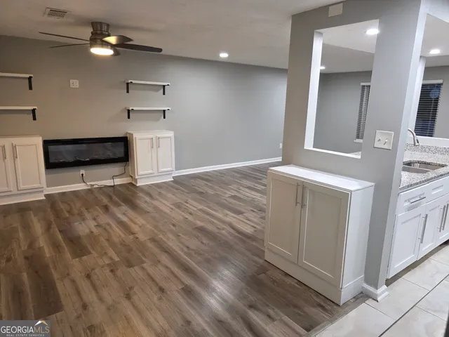 wooden floor in an empty room with a kitchen