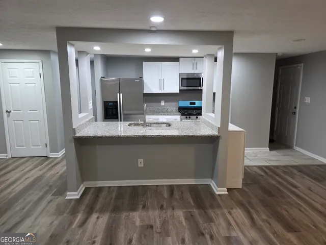 a view of kitchen with refrigerator microwave and wooden floor