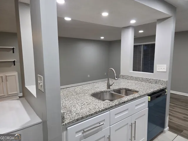 a kitchen with sink and mirror