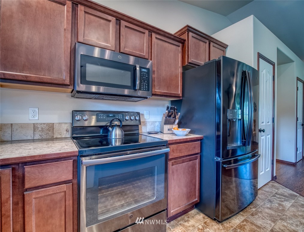 5125 180th Trail Southwest Rochester, WA 98579 - Photo 12 of 25 a kitchen with stainless steel appliances granite countertop a stove microwave and refrigerator