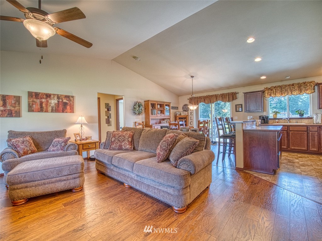 5125 180th Trail Southwest Rochester, WA 98579 - Photo 10 of 25 a living room with furniture kitchen area and a wooden floor