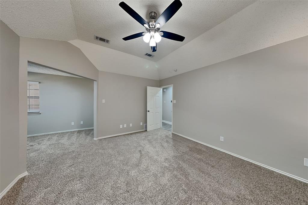 3920 Winston Drive Denton, TX 76210 - Photo 8 of 20 Unfurnished bedroom featuring carpet flooring, a textured ceiling, lofted ceiling, and ceiling fan
