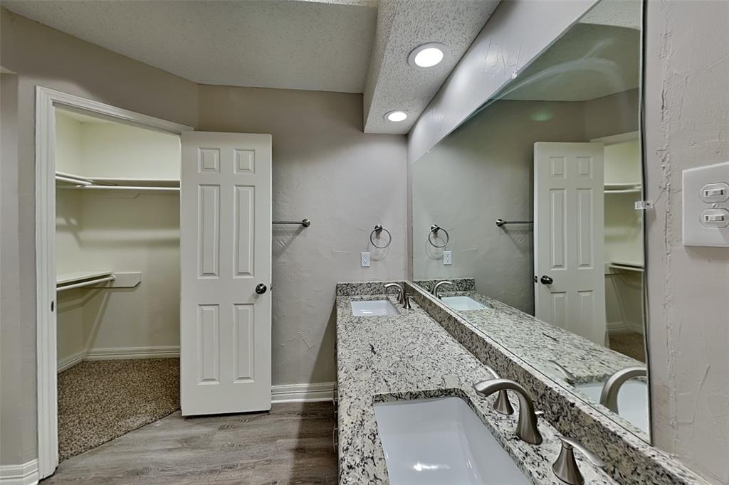 3920 Winston Drive Denton, TX 76210 - Photo 10 of 20 Full bathroom featuring a walk in closet, light wood finished floors, double vanity, a textured ceiling, and a textured wall