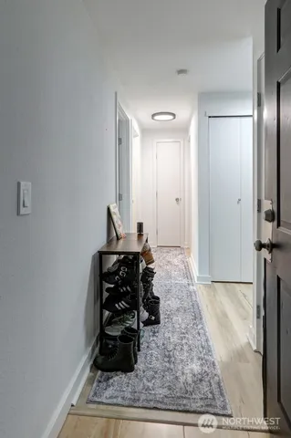 a view of a hallway with wooden floor and living room