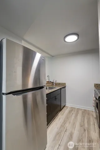 a view of a kitchen with a sink and a refrigerator