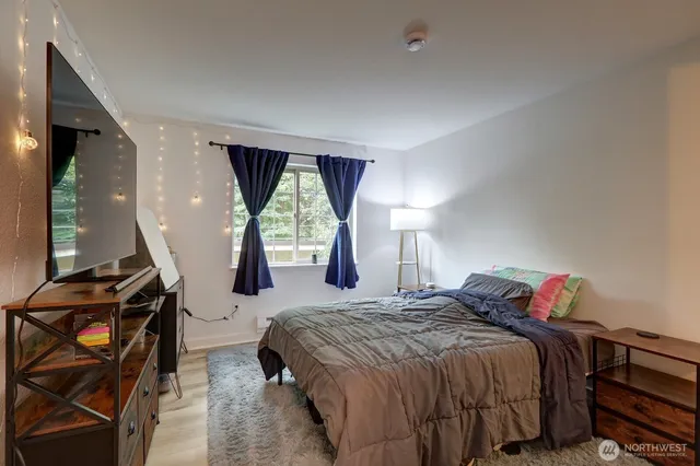 a bedroom with a bed and wooden floor