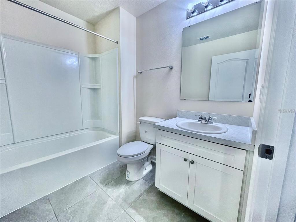 199 Redbud Road Palm Coast, FL 32137 - Photo 11 of 23 a bathroom with a sink a toilet and a large mirror