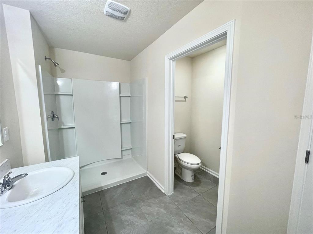 199 Redbud Road Palm Coast, FL 32137 - Photo 18 of 23 a bathroom with a granite countertop toilet a sink and a mirror