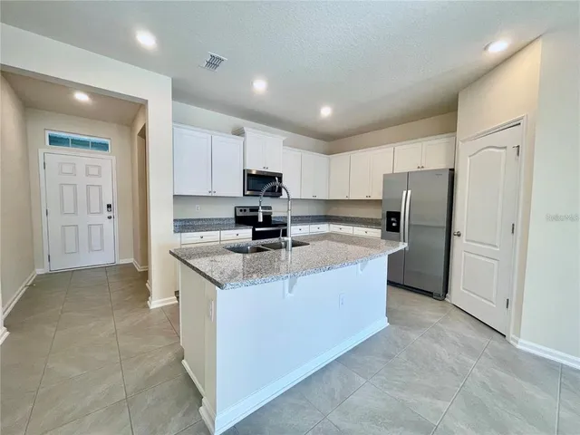 a large kitchen with cabinets and stainless steel appliances