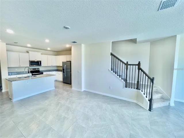 a large kitchen with a refrigerator and a stove top oven