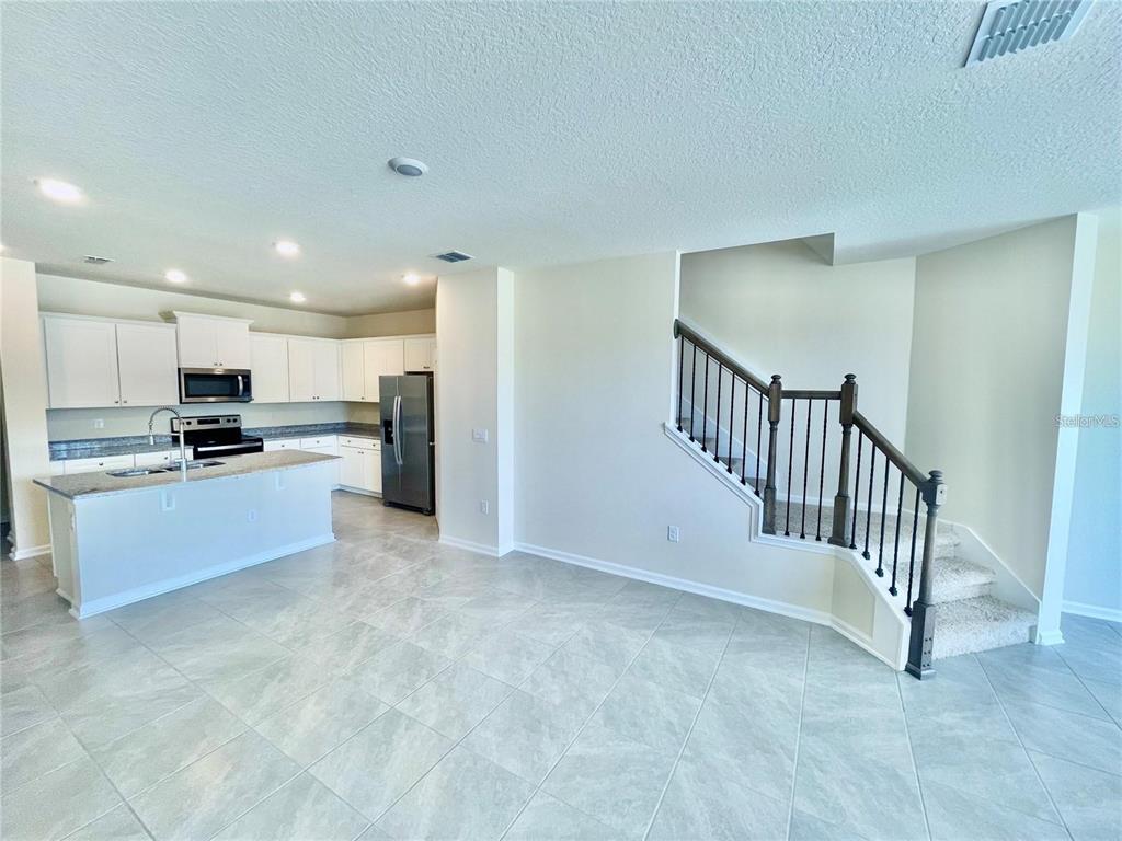 199 Redbud Road Palm Coast, FL 32137 - Photo 5 of 23 a large kitchen with a refrigerator and a stove top oven