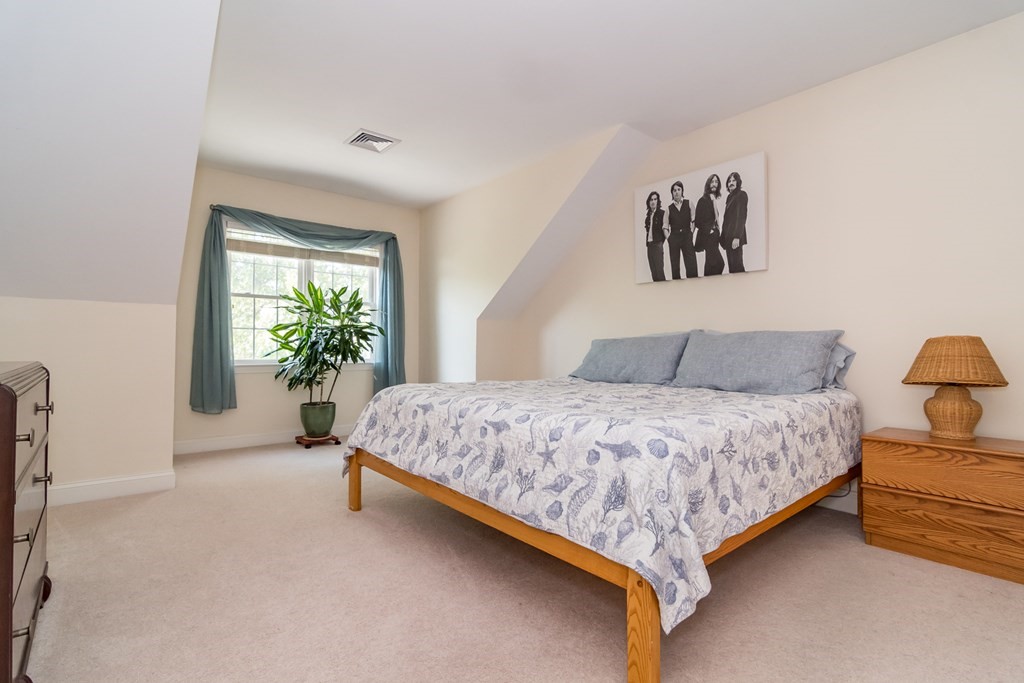 28 Prestwick Road, Unit 188 Bourne, MA 02532 - Photo 24 of 41 a spacious bedroom with a bed and a potted plant