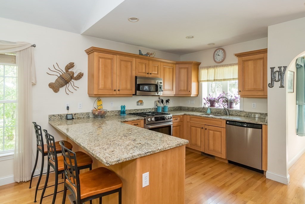 28 Prestwick Road, Unit 188 Bourne, MA 02532 - Photo 8 of 41 a kitchen with granite countertop kitchen island a stove a sink a dining table and chairs