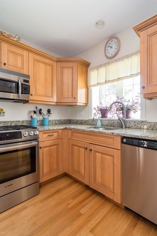 28 Prestwick Road, Unit 188 Bourne, MA 02532 - Photo 10 of 41 a kitchen with stainless steel appliances granite countertop a stove a sink and a microwave