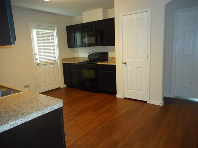 a kitchen with granite countertop a stove and a sink