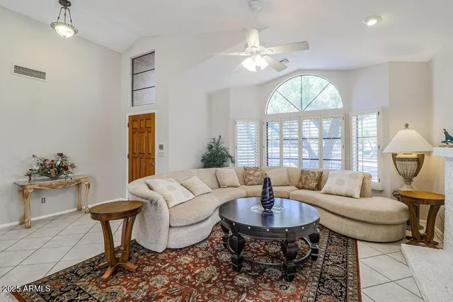 a living room with furniture a dining table and a chandelier